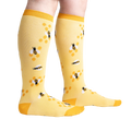 Lifestyle shot of model wearing yellow bee socks, showcasing fit and style.