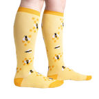 Lifestyle shot of model wearing yellow bee socks, showcasing fit and style.