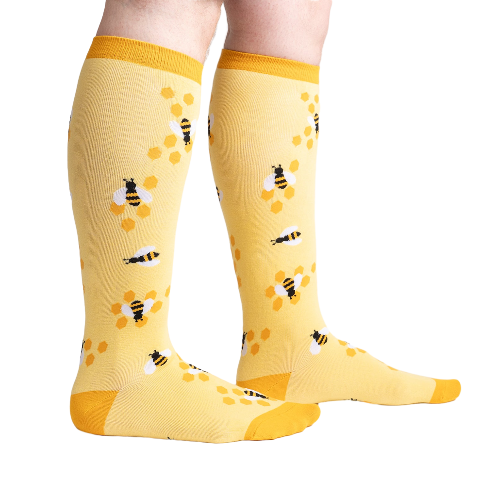 Lifestyle shot of model wearing yellow bee socks, showcasing fit and style.