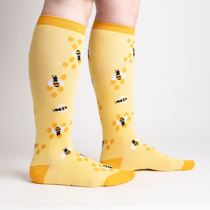 Lifestyle shot of model wearing yellow bee socks, showcasing fit and style.