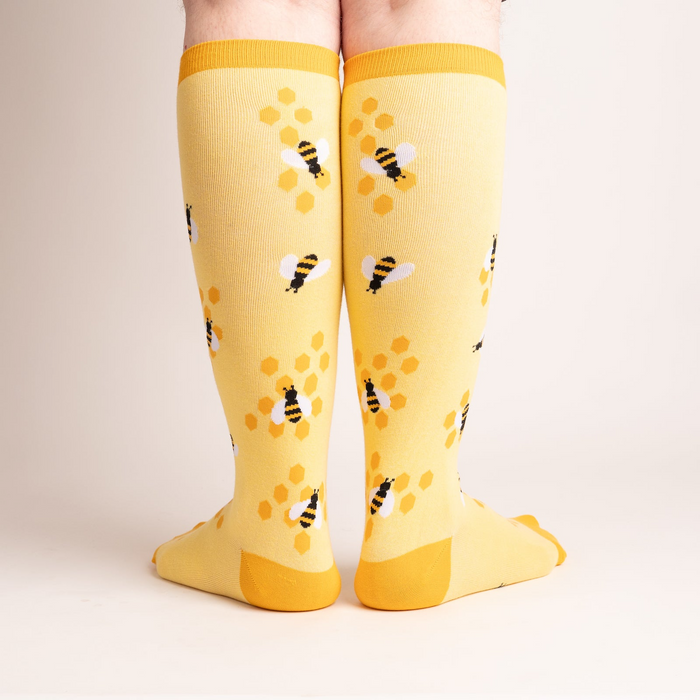 Rear view of the yellow bee socks, highlighting the honeycomb design on the back.