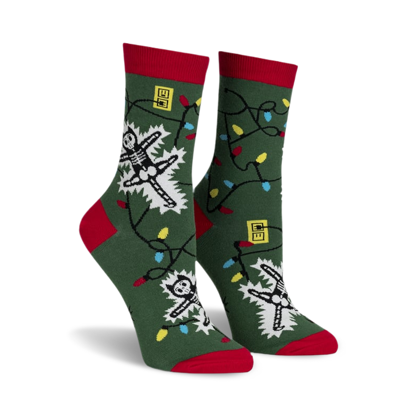Crew socks in green with red cuffs, featuring skeletons tangled in colorful Christmas lights.  Glows in the dark!