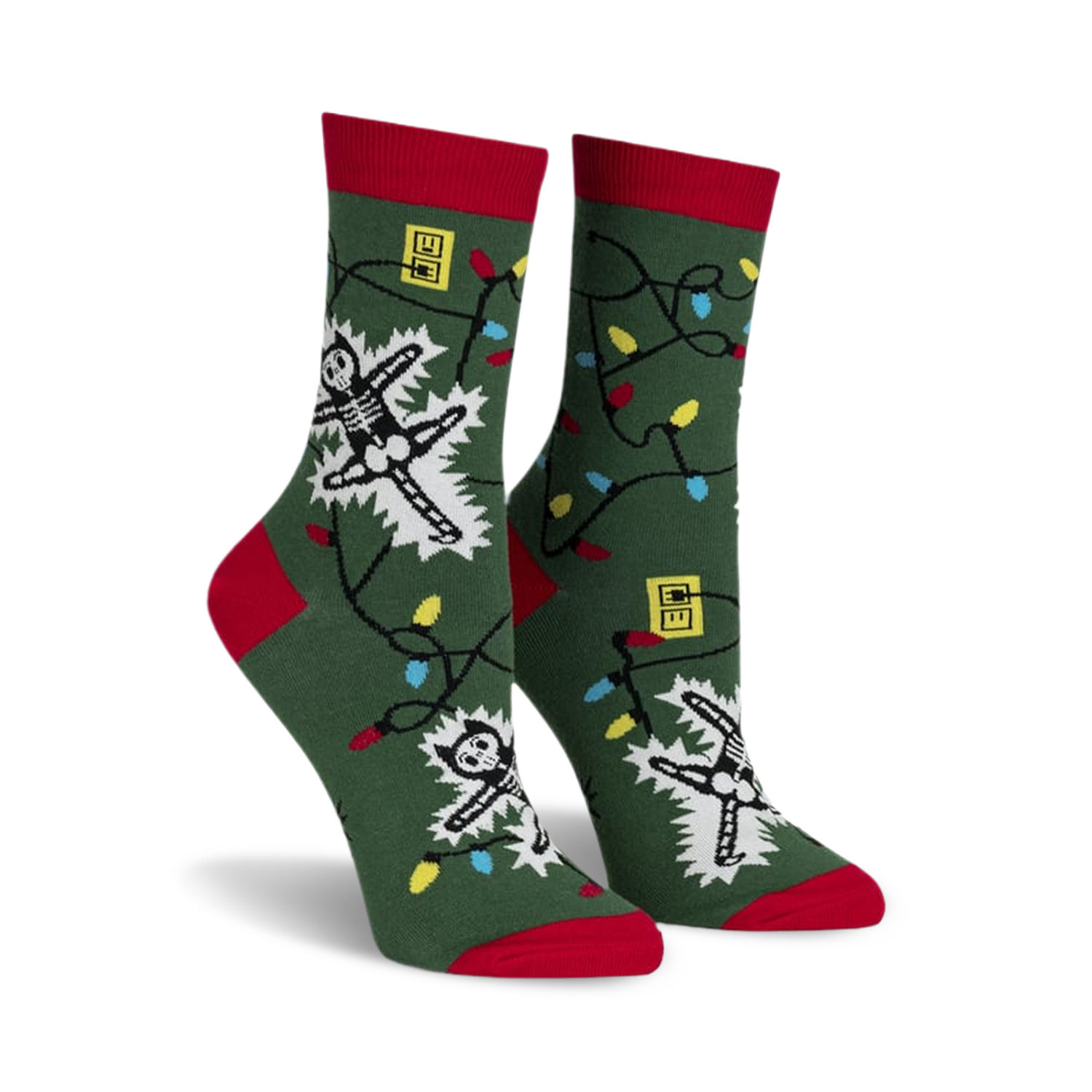 Crew socks in green with red cuffs, featuring skeletons tangled in colorful Christmas lights.  Glows in the dark!