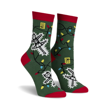 front view of a pair of green socks with christmas lights and a skeleton getting electrocuted. the socks have red cuffs.