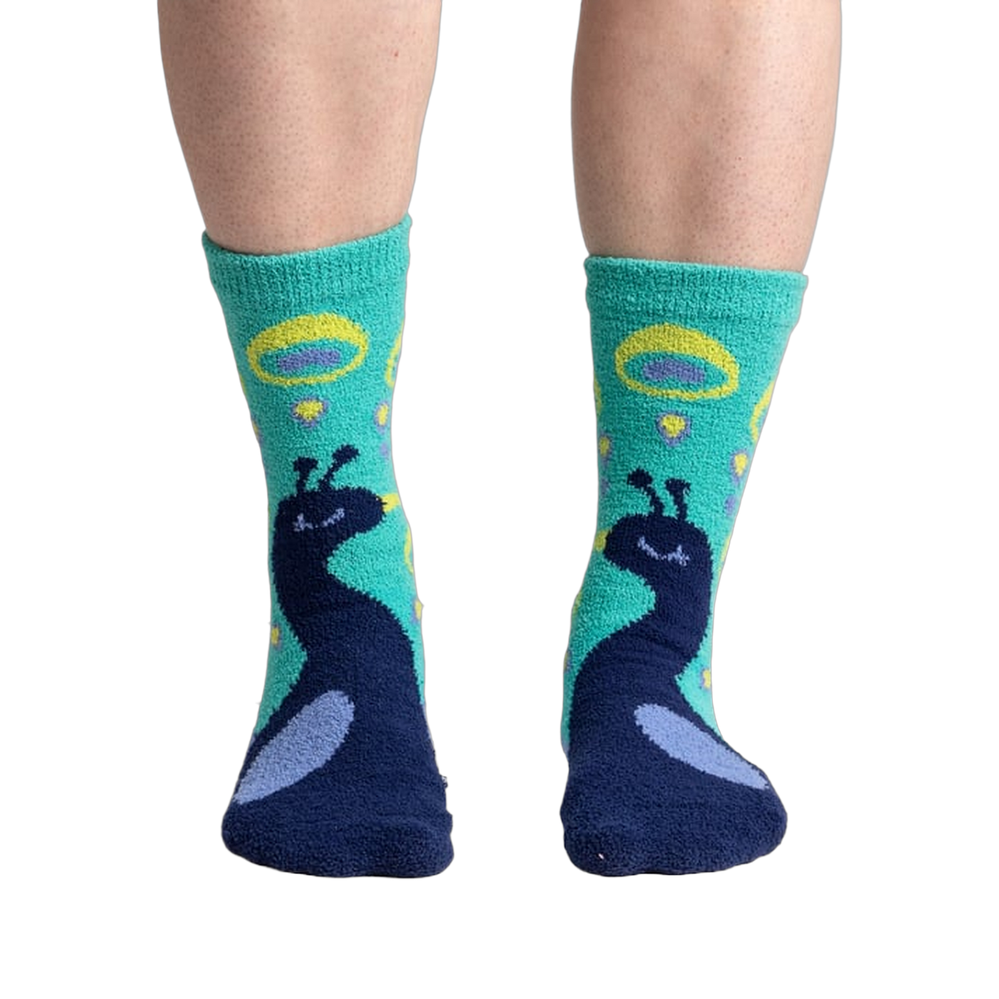Close-up shot of 'I'm Your Biggest Fan' slipper socks on a person's feet, showcasing the teal and navy peacock design.