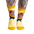 Lifestyle shot of a person wearing the yellow butterfly slipper socks, showcasing the fit and feel.