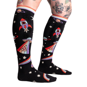 A pair of black knee-high socks with a pattern of rockets, planets, and stars in bright colors.