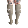 Rear view of the Orchid knee-high socks on a model, showcasing the full floral design on the back of the legs.