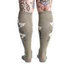 Rear view of the Orchid knee-high socks on a model, showcasing the full floral design on the back of the legs.