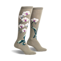 Pair of women's knee-high socks in sage green with a design of white orchids and dark green leaves.