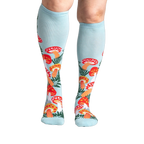 Lifestyle shot showcasing the Wonderland Mushrooms knee-high socks on a model's legs.