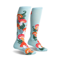Pair of pastel blue knee-high socks adorned with a whimsical pattern of red and orange mushrooms and green ferns.