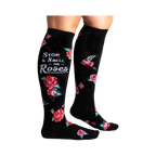 Lifestyle shot: Woman's legs wearing black knee-high socks with red roses and a phrase.