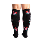 Rear view of black knee-high socks with a rose pattern and text.