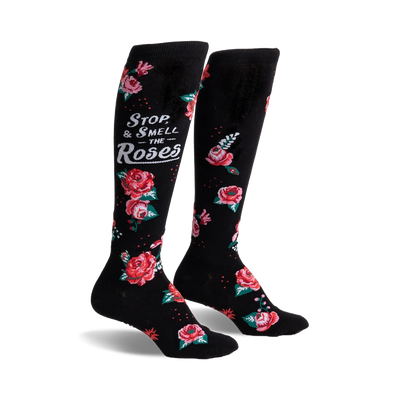 black knee-high socks with a floral pattern of red, pink, and white roses and the message "stop and smell the roses" in white script.  