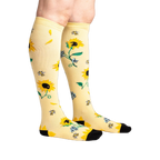 Lifestyle shot: Person wearing the sunflower knee-high socks, showing the design on the legs.