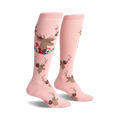 Pair of pink knee-high socks featuring a repeating pattern of gold deer heads accented with red and teal flowers.