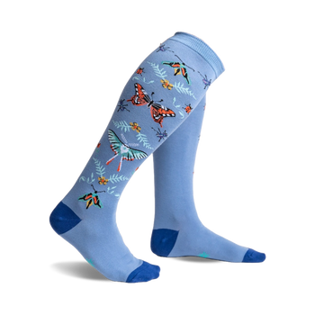 blue background knee-high butterfly socks with colorful insects, green leaves, and yellow flowers. for women.   