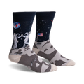 Pair of crew socks; navy blue with astronauts high-fiving on the moon, a US flag, and a lunar landscape. The foot features a grey moon rock pattern.