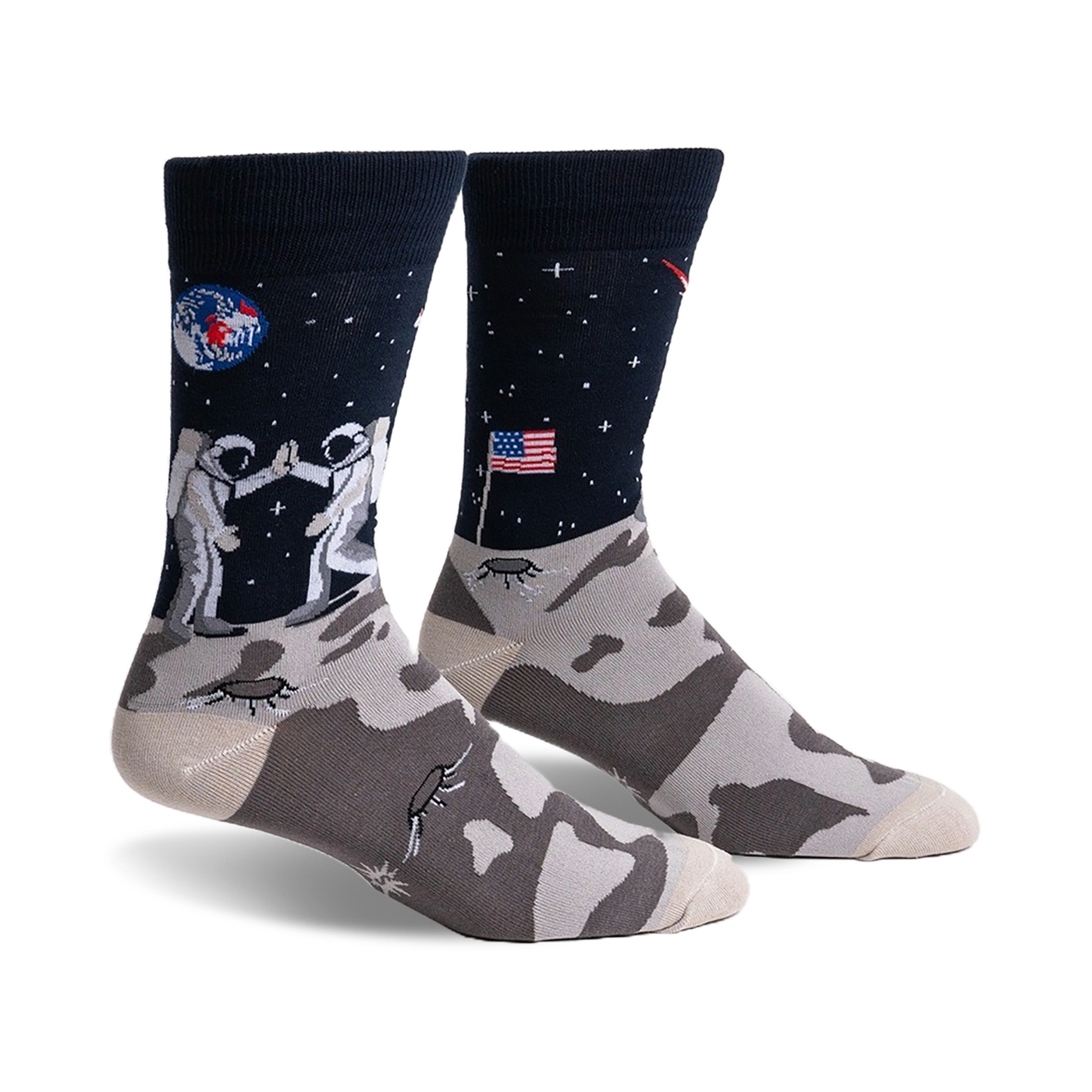 Pair of crew socks; navy blue with astronauts high-fiving on the moon, a US flag, and a lunar landscape. The foot features a grey moon rock pattern.