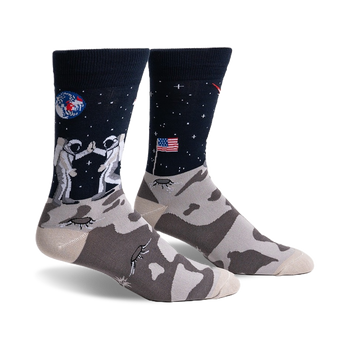 black crew socks with gray toes and heels feature two astronauts on the moon, the earth, and american flag graphics.  
