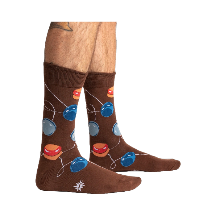 Lifestyle shot of a man's legs wearing the brown yo-yo socks.