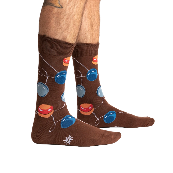 A pair of brown socks with a pattern of red, blue, and yellow balloons on them.