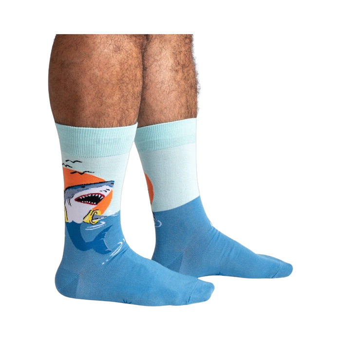 Lifestyle shot of a person wearing the teal and light blue shark socks.