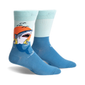 A pair of crew socks with a graphic of a shark catching a life preserver at sunset. The socks are teal and light blue.