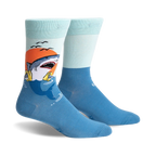 A pair of crew socks with a graphic of a shark catching a life preserver at sunset. The socks are teal and light blue.