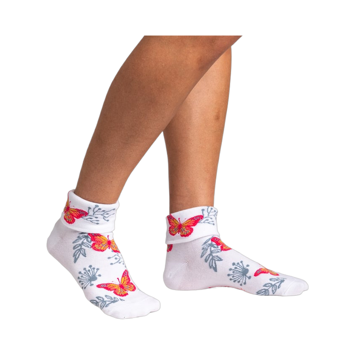 Pair of women's white ankle socks with butterfly and floral pattern shown from the front.