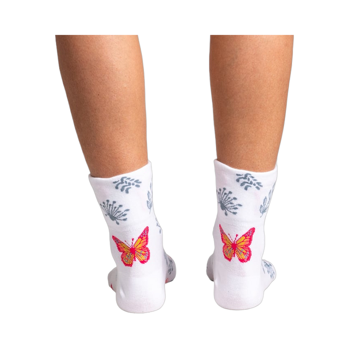 Close-up detail shot of a vibrant orange and pink butterfly design on the sock.