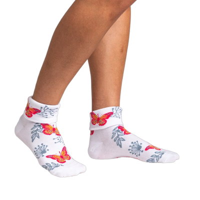 Women's white ankle socks with a turn-cuff, featuring orange and pink butterflies and gray floral designs.