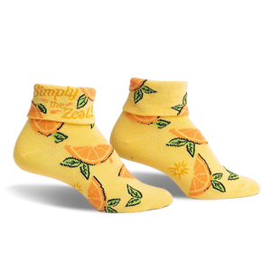 front view of two pairs of yellow socks with orange slices and green leaves on them.  the top of the socks says 