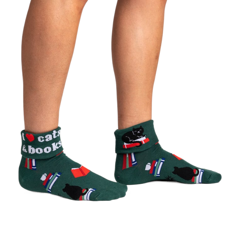 Lifestyle photo showcasing the 'I Love Cats & Books' socks on a person's feet.