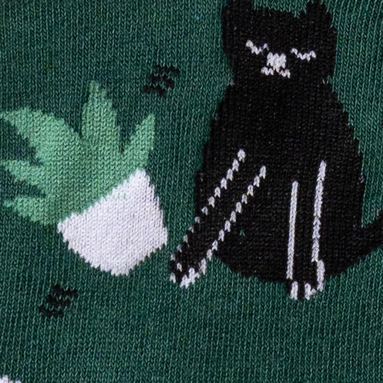 Close-up of a section of the sock showing a black cat and a stack of books.