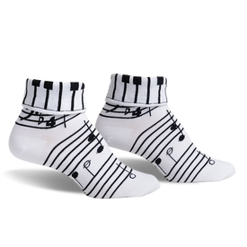 pair of white socks with black piano keys and musical notes on the top of the sock and music notes on the rest of the sock. front view of the socks.