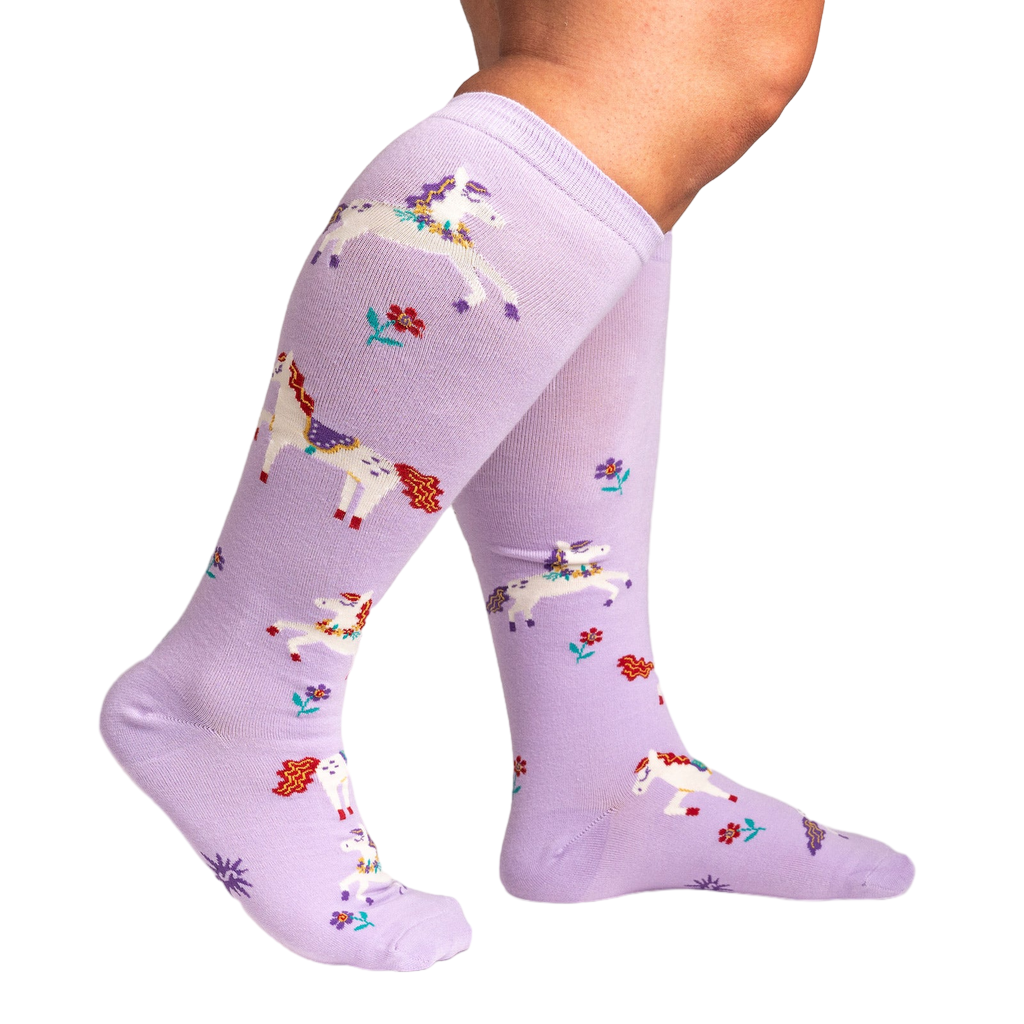 Lifestyle shot showing the lavender unicorn socks on a person's legs, highlighting the extra stretch.