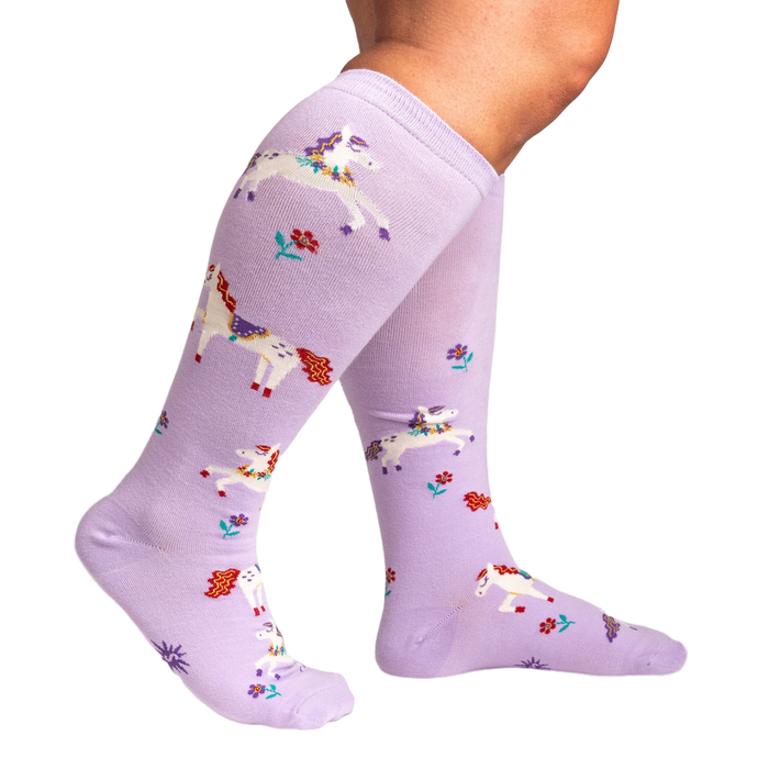 Lifestyle shot showing the lavender unicorn socks on a person's legs, highlighting the extra stretch.