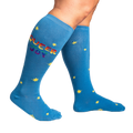 Lifestyle shot: Person wearing blue knee-high socks with 'Queer Joy' and stars. Shows the fit and style.