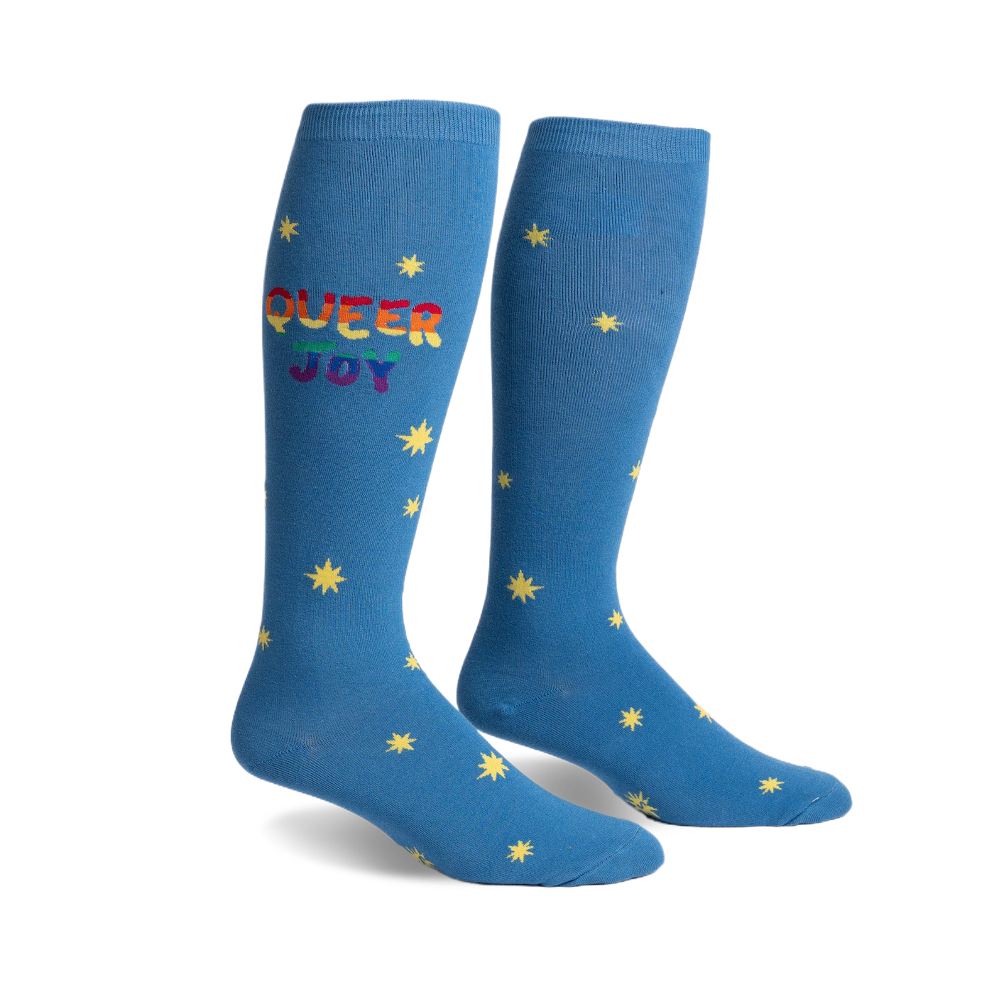 Pair of blue knee-high socks.  Rainbow 'Queer Joy' text and yellow star pattern.