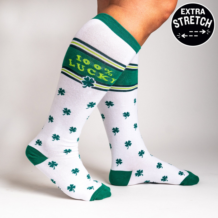 Lifestyle shot showing a person's legs wearing the '100% Lucky' knee-high socks, highlighting their fit and stretch.