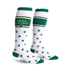 Pair of white knee-high socks with green shamrock pattern, green stripes, and '100% Lucky' text.