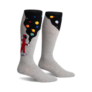 Pair of grey knee-high socks. One side features a cartoon astronaut, planets, and a black space-like design, the other side is solid grey.