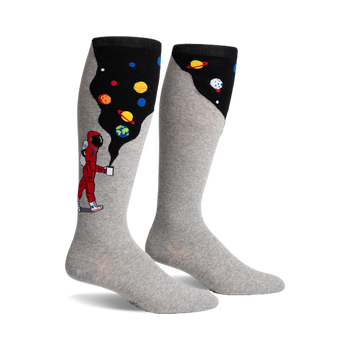 Pair of grey knee-high socks. One side features a cartoon astronaut, planets, and a black space-like design, the other side is solid grey.