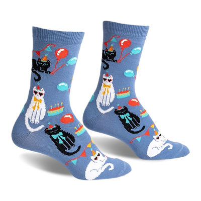 front view of a pair of socks with a blue background and cats wearing party hats. there are also balloons and cake on the socks.