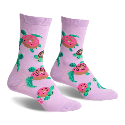 front view of a pair of purple socks with a pattern of green sea turtles eating pink and white donuts.