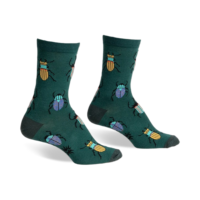 A pair of green crew socks with a whimsical pattern of colorful beetles. Yellow and blue beetles are scattered on a dark-green background.