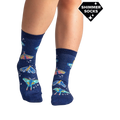 Lifestyle shot of a person's legs wearing the Moonlit Moth Shimmer socks, showing the socks on feet.