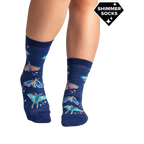 Lifestyle shot of a person's legs wearing the Moonlit Moth Shimmer socks, showing the socks on feet.
